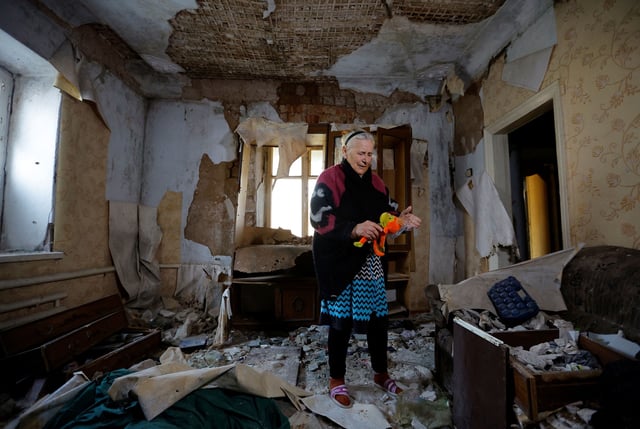 Local resident Valentina Ryabokrys, 85, standing inside her Mariupol house that had been destroyed by the fighting.