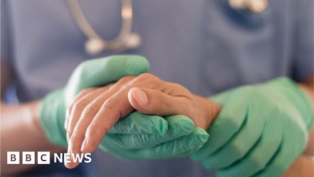 Anaesthetist or anaesthesiologist holding patient's hand