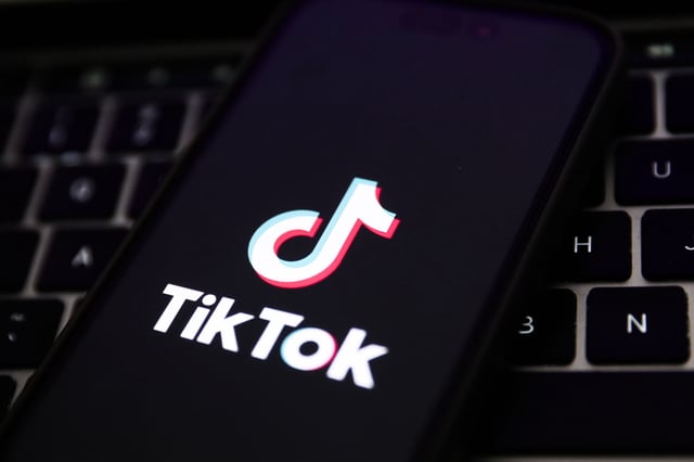 A laptop keyboard and TikTok logo displayed on a phone screen are seen in this illustration photo taken in Krakow, Poland on February 7, 2024. (Photo by Jakub Porzycki/NurPhoto via Getty Images)