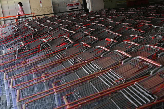 A shopper wearing a protective face mask walks past a shopping cart corral outside of a Costco store amid the coronavirus disease (COVID-19) outbreak in Wheaton, Maryland, U.S., May 18, 2020.