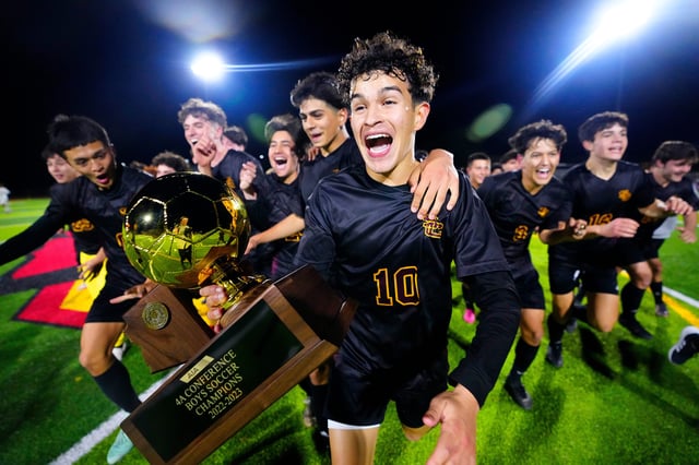Salpointe Catholic senior Nico Valenzuela runs off the pitch with his teammates carrying the 4A Championship Trophy after they beat Saguaro 4-1 at Glendale High School on Feb. 24, 2023.
