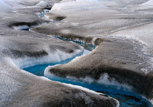 Brown sediment on melting ice near Kangerlussuaq in Greenland. Rapid ice melt is having a number of impacts on Greenland's landscape, including sedimentation of its waters.