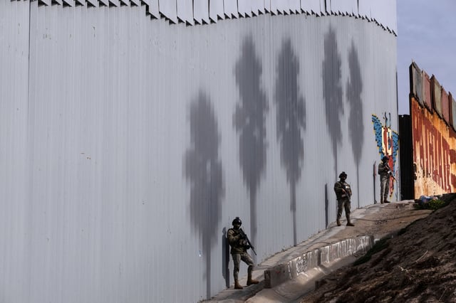 Mexican Navy officers guard border wall