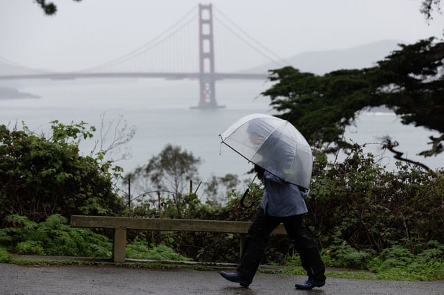 Negina Rood walks in the rain near Lands End in San Francisco on Saturday, Feb. 17. Meteorologists forecast a series of new storms starting Saturday and intensifying over the holiday weekend into next week.