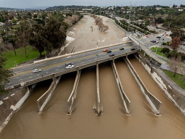 Drone view of the LA River full of muddy run-off water from the atmospheric river rain storm. Much of LA's rainwater becomes run-off and flows via the LA River in to the Pacific Ocean. The 51 mile long LA River was built originally as a flood control channel to handle heavy rain fall run-off. 2/6/2024 LOS ANGELES, CA., USA (Photo by Ted Soqui/SIPA USA)(Sipa via AP Images)