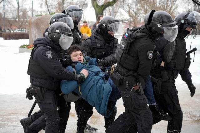 Police detain a man trying to pay respects to Alexei Navalny in St Petersburg, Russia on Saturday. Photo: AP