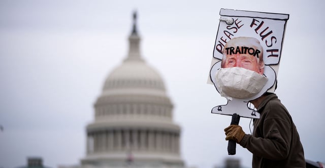 Bill Wood demonstrates with an anti-Trump sign near the U.S. Capitol on Jan. 6, 2022, in Washington, D.C. (Photo: Drew Angerer/Getty Images)
