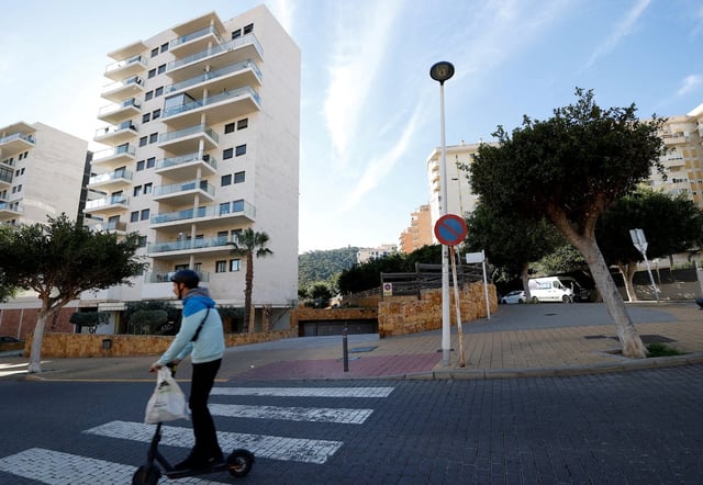 Person rides a scooter past building in southeastern Spain where Maxim Kuzminov was found dead