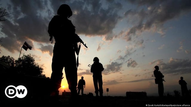 Russian soldiers are seen at sunset before finishing the Russian troops' withdrawal at a checkpoint near the city of Gori