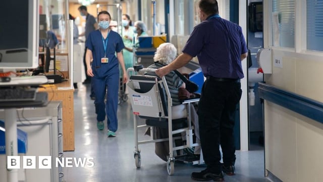 A patient on a hospital ward with medical staff
