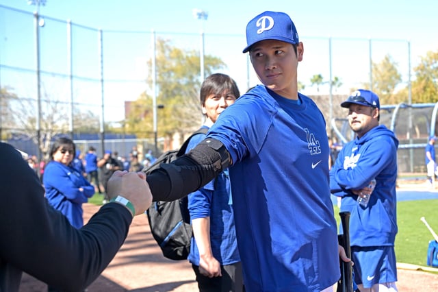 Los Angeles Dodgers designated hitter Shohei Ohtani (17) talks with former Los Angeles Angels manager Phil Nevin in the dugout during spring training at Camelback Ranch.