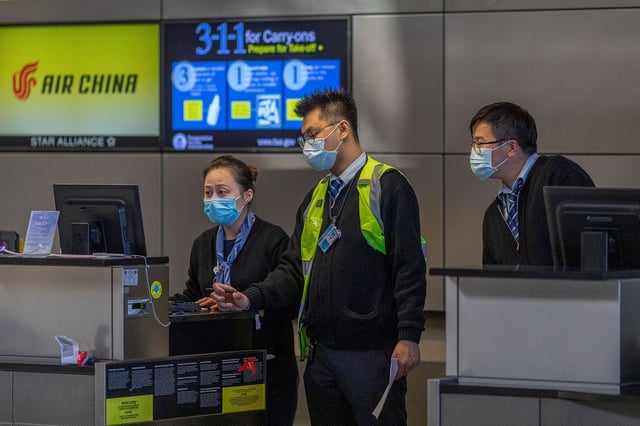 Air China employees wear medical masks at LAX Tom Bradley International Terminal on February 2, 2020, in Los Angeles, California.