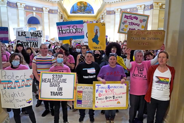 Trans-rights activists protest outside the House chamber at the Oklahoma Capitol before the State of the State address, Feb. 6, 2023, in Oklahoma City. On Monday, May 1, Oklahoma became the latest state to ban gender-affirming medical care for minors as Republican Gov. Kevin Stitt signed a bill that makes it a felony for health care workers to provide children with treatments that can include puberty-blocking drugs and hormones. (AP Photo/Sue Ogrocki)