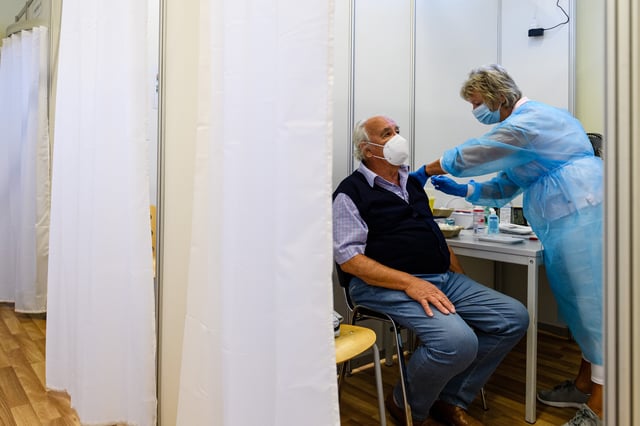 ERFURT, GERMANY - SEPTEMBER 15: Medical staff member inoculates an elderly patient with a booster inoculation of the Pfizer/BioNTech vaccine against Covid-19 on September 15, 2021 in Erfurt, Germany. Booster vaccinations, which are an additional vaccination shot given to strengthen an existing full vaccination, are underway across Germany for elderly patients who were among the first to receive shots in the initial vaccine rollout. (Photo by Jens Schlueter/Getty Images)