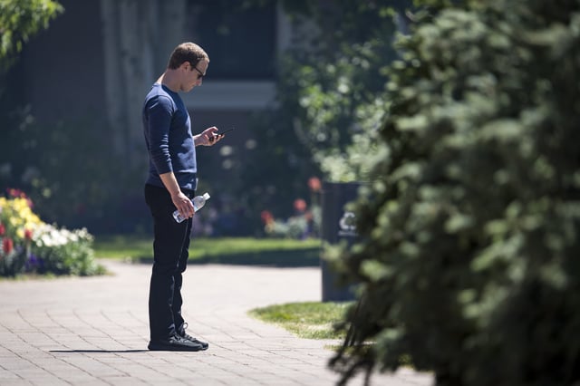 Mark Zuckerberg, chief executive officer and founder of Facebook Inc., looks at his phone after the morning session at the Allen & Co. Media and Technology Conference in Sun Valley, Idaho, U.S., on Friday, July 13, 2018. The 35th annual Allen & Co. conference gathers many of America's wealthiest and most powerful people in media, technology, and sports. Photographer: David Paul Morris/Bloomberg via Getty Images