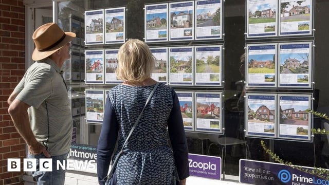 People looking in estate agent window