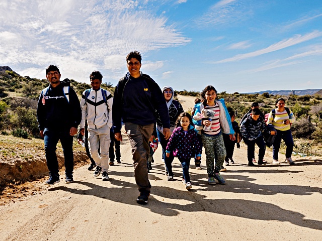 SAN DIEGO, CALIFORNIA - FEBRUARY 23: Migrants walk on a dirt road after crossing the nearby border with Mexico near the Jacumba Hot Springs on February 23, 2024 in San Diego, California. (Photo by Qian Weizhong/VCG via Getty Images)