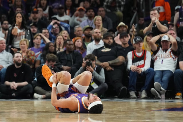 Phoenix Suns guard Devin Booker (1) reacts after being inured against the Houston Rockets during the second half at Footprint Center.