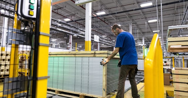 A worker builds a crate for solar panels at First Solar in Perrysburg, Ohio July 8, 2022.  REUTERS/Megan Jelinger/file photo