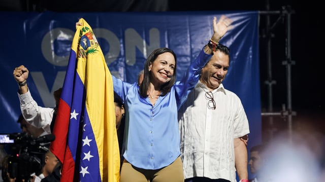 Maria Corina Machado holds the Venezuelan flag as she waves to her supporters after being named the winner of the opposition’s presidential primary election, Caracas, Venezuela, Oct. 23, 2023 (DPA photo by Jesus Vargas via AP Images).