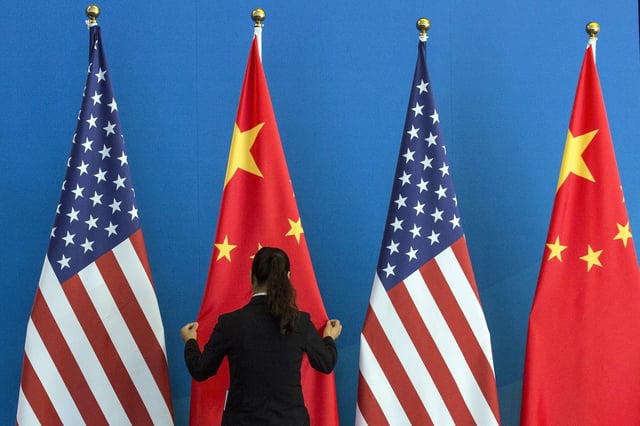A woman adjusts a flag during the U.S.-China Strategic and Economic Dialogue in Beijing on July 10, 2014.