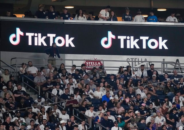 Fans sit under a TikTok ad at a baseball game at Yankee Stadium, April 14, 2023, in New York. Photo: AP