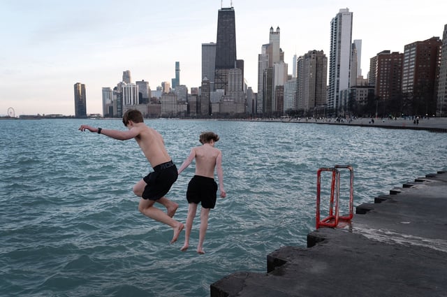 Kids jump into Lake Michigan during unseasonably warm conditions in Chicago on February 26, 2024.