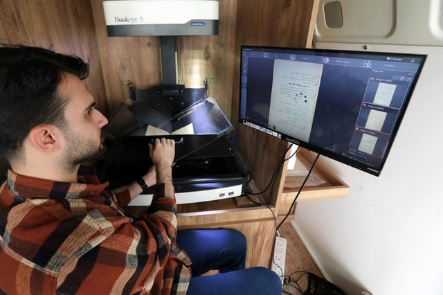 A member of the Kurdistan Centre for Arts and Culture in the Iraqi city of Dohuk scans the pages of a rare book, part of a project to digitise Kurdish literary and historical works