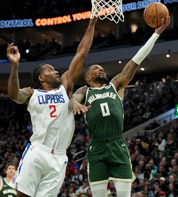 Milwaukee Bucks guard Damian Lillard (0) scores on LA Clippers forward Kawhi Leonard (2) during the first half of their game Monday, March 4, 2024 at Fiserv Forum in Milwaukee, Wisconsin.\
