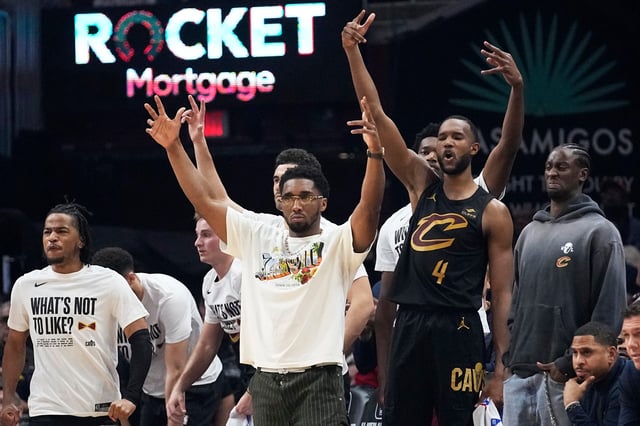 Cleveland Cavaliers' Donovan Mitchell (center) and Evan Mobley (4) cheer in the bench area in the first half of an NBA basketball game against the New York Knicks on March 3, 2024, in Cleveland.