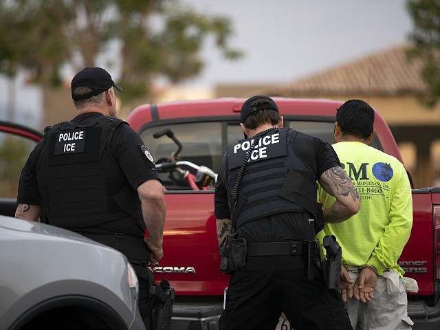 In this July 8, 2019, photo, a U.S. Immigration and Customs Enforcement (ICE) officers detain a man during an operation in Escondido, Calif. A federal judge has prohibited U.S. immigration authorities from relying on databases deemed faulty to ask law enforcement agencies to hold people in custody, a setback for the Trump administration that threatens to hamper how it carries out arrests. (AP Photo/Gregory Bull)
