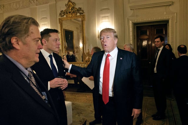 Trump advisor Steve Bannon (left) watches as then-President Donald Trump greets Elon Musk, SpaceX and Tesla CEO, before a policy and strategy forum with executives in the State Dining Room of the White House on February 3, 2017, in Washington, D.C.