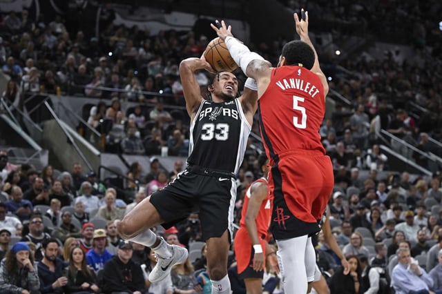 San Antonio Spurs' Tre Jones (33) goes to the basket as Houston Rockets' Fred VanVleet defends during the first half of an NBA basketball game Tuesday, March 12, 2024, in San Antonio. (AP Photo/Darren Abate)