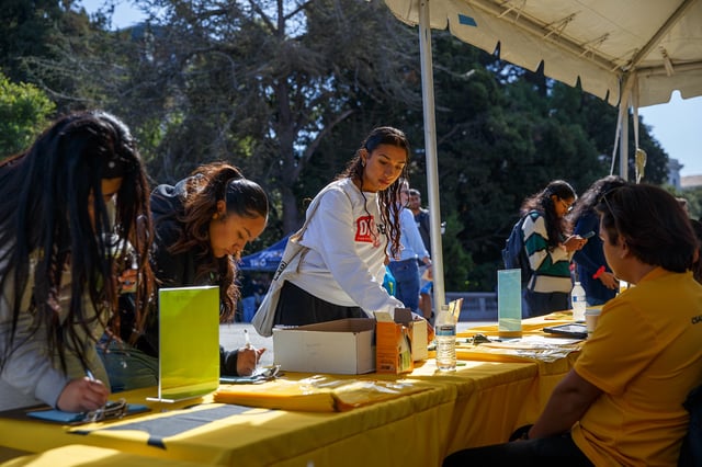 Prospective college applicants visit the California Student Aid Commission booth at College Information Day at UC Berkeley in Berkeley on Oct. 14, 2023. CSAC held informational sessions on financial aid to help inform students and their families about their options. Photo by Juliana Yamada for CalMatters