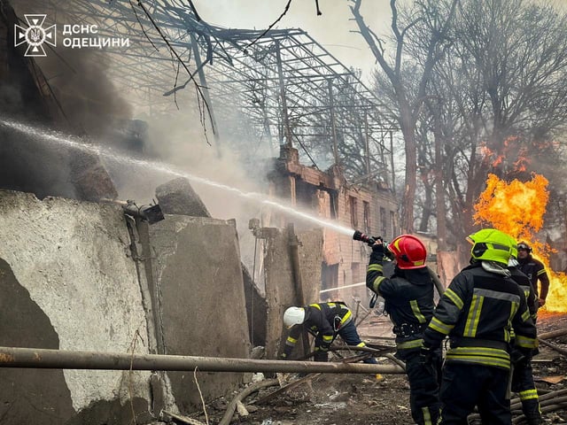 Emergency services try to extinguish a fire caused by the Russian missile strike.