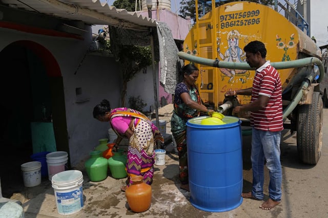 Residents of Ambedkar Nagar, a low-income settlement in the shadows of global software companies in Whitefield neighborhood, collect potable water from a private tanker in Bengaluru, India, Monday, March 11, 2024. Water levels are running desperately low, particularly in poorer regions, resulting in sky-high costs for water and a quickly dwindling supply.
