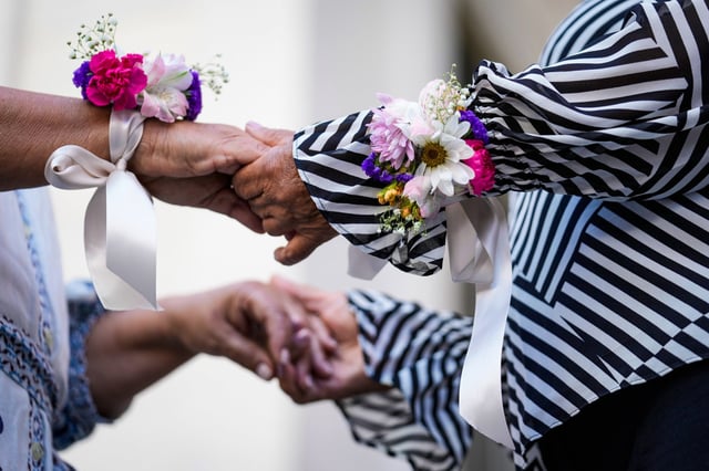 Maribel Gutierrez, 66, left, holds hands with Emilse Gonzalez, 70, as they are married during a Valentine's Day group wedding ceremony on the steps of the Dade County Courthouse in Miami on Feb. 14, 2024.