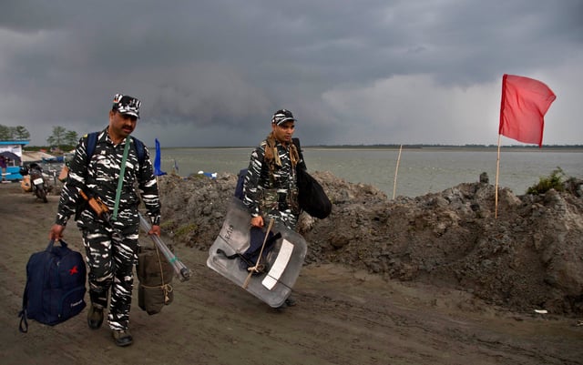 Paramilitary soldiers carry their luggage after disembarking from a ferry across the Brahmaputra river in Assam state ahead of the first phase of elections in April 2019. Photo: AP