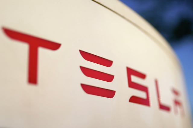 The Tesla logo is seen on a Supercharger station in Georgia. On Tuesday, two men were accused of starting a business in China using battery manufacturing technology pilfered from Texas-based Tesla and trying to sell the proprietary information.