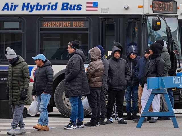 Migrants stand in line to receive food from the nonprofit Chi-Care Thursday, Jan. 11, 2024, in Chicago. In the city of Chicago's latest attempt to provide shelter to incoming migrants, several CTA buses were parked in the area of 800 South Desplaines Street to house people in cold winter weather. (AP Photo/Erin Hooley)