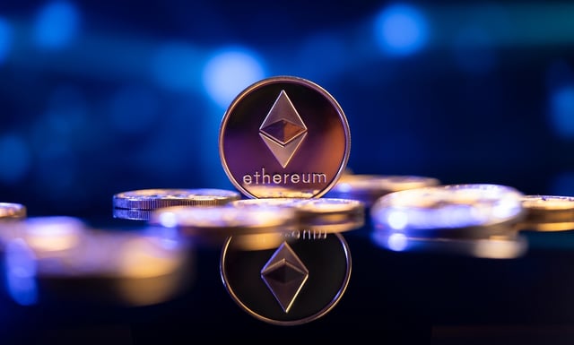 Ethereum (ETH) cryptocurrency coin in front of an abstract blue virtual background