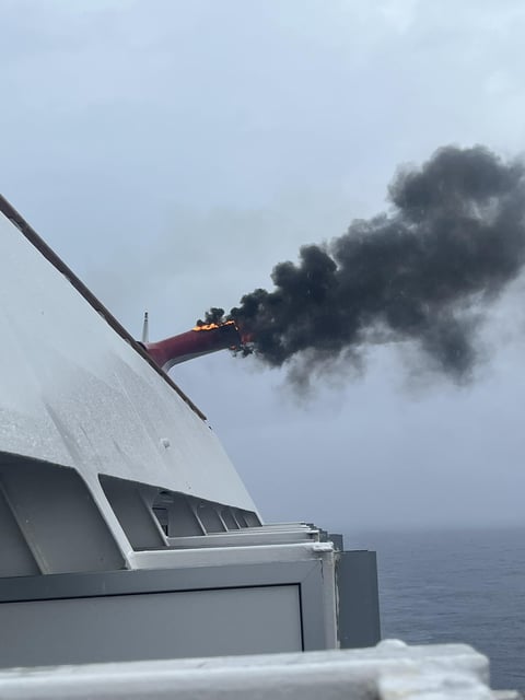 Heath Barnes took this photo of fire and smoke pouring out of an exhaust funnel of the Carnival Freedom cruise ship near Eleuthera Island, Bahamas, on Saturday, March 23.