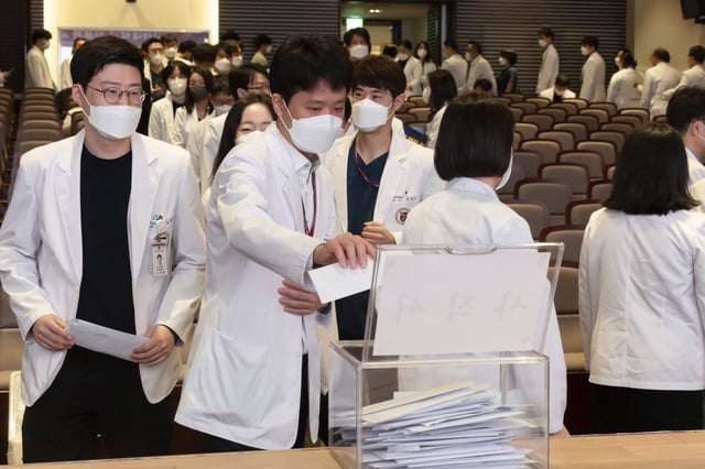 Medical professors queue to submit their resignations during a meeting at Korea University in Seoul, South Korea, Monday, March 25, 2024. Senior doctors at dozens of hospitals in South Korea planned to submit their resignations Monday in support of medical interns and residents who have been on a strike for five weeks over the government’s push to sharply increase medical school admissions, their leader said.(Yoon Dong-jin/Yonhap via AP)