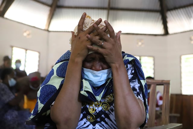 A family member grieves as she waits to receive the bodies of victims of a religious cult for burial. Photo: AP