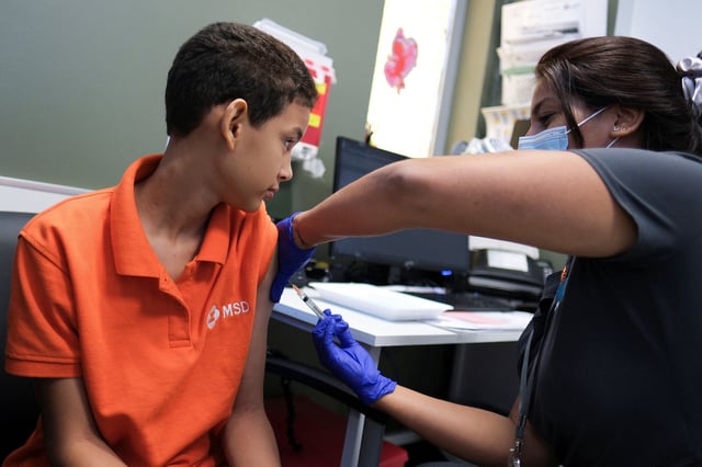 A registered nurse, Kayla Feliciano injects a dose of the dengue vaccine Dengvaxia to Alberto Luis Nunez, 12, after a spike in dengue fever cases in San Juan, Puerto Rico, March 27, 2024.
