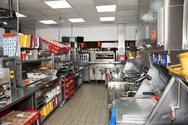 Commercial kitchen in a fast food restaurant, clean and empty as if untouched.