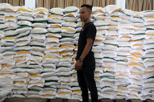 A worker gets ready to distribute rice sacks during a food aid distribution drive in Banda Aceh on March 6. Photo: EPA-EFE