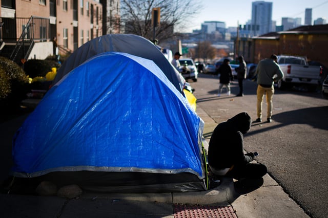 People pack and prepare to leave a migrant encampment in Denver, on Jan. 3, 2024.