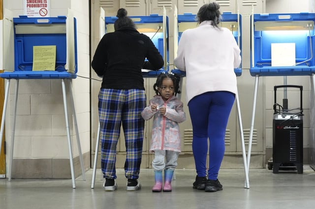 K-Lee, 3, waits as her mother Heather Ramsey votes on April 2, 2024, in Milwaukee. 