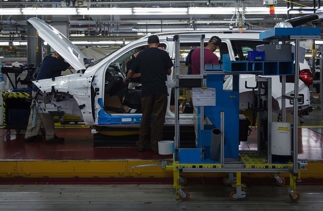 Employees install parts on a Mercedes-Benz GLS-Class SUV as it moves down the production line at the Mercedes-Benz US International factory in Vance, Alabama on June 8, 2017.